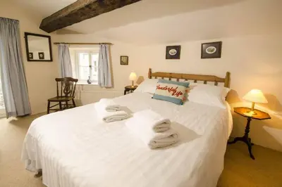 a bedroom with a large white bed with towels on it at Juniper Grasmere - Juniper Cottage, Grasmere in Grasmere