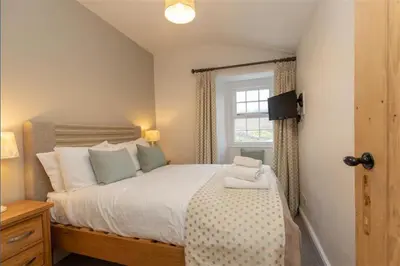 a bedroom with a large bed with a window at Victory Cottage - Victory Cottage, Cosy village retreat in Chapel Stile