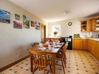 a kitchen with a wooden table and chairs in a room at Cairn-O-Mhor in Lendalfoot