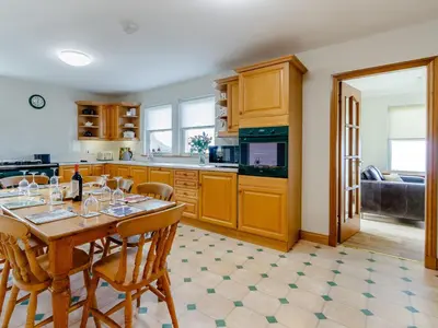 a kitchen with a table and chairs and a kitchen with a couch at Cairn-O-Mhor in Lendalfoot