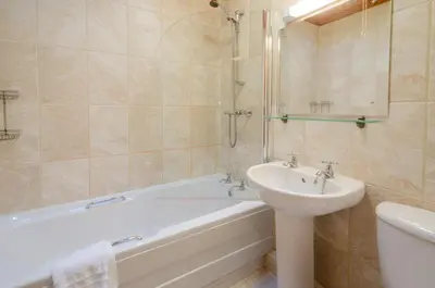 a bathroom with a bath tub and a sink and a bath tub at Langdale Retreat in Chapel Stile
