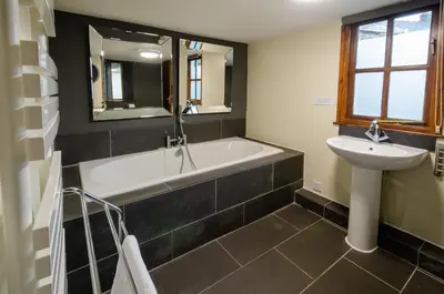 a bathroom with a bath tub and a sink at Langdale Retreat in Chapel Stile