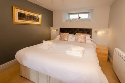 a bedroom with a large white bed with towels on it at Langdale Retreat in Chapel Stile