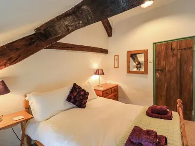 a bedroom with a white bed and a wooden ceiling at Blease Garth in Threlkeld