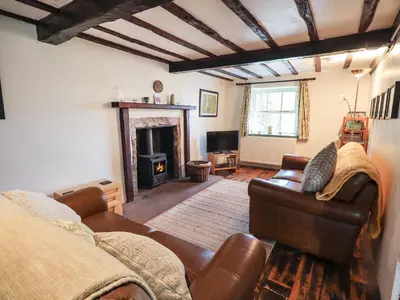 a living room with a couch and a fireplace at Blease Garth in Threlkeld