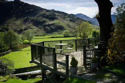 a wooden fence with a table and a table at Heron Place, Great Langdale in Ambleside