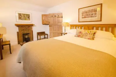 a bedroom with a large bed and a fireplace at Heron Place, Great Langdale in Ambleside