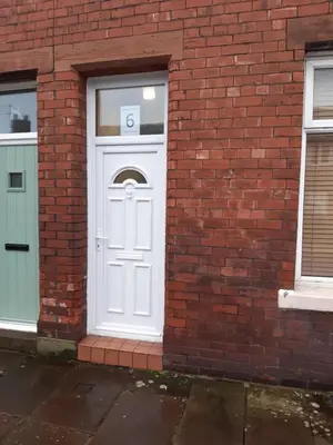 a white door in a brick building with a letter on it at Carvetii - Quentin House - Near Hospital, max 7 ppl in Carlisle
