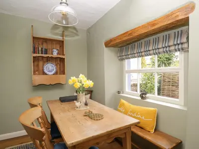 a dining room with a wooden table and chairs at Beckside Cottage in Welton