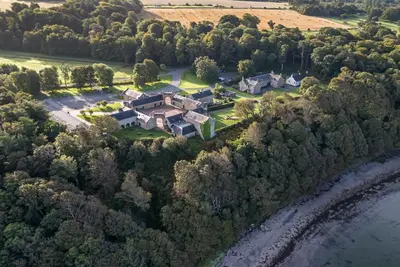 an aerial view of a large house on the water at North Segganwell - Culzean Castle in Maybole