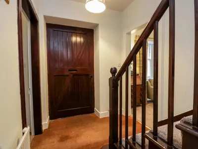 a hallway with a wooden door in a house at Gate Lodge - Threave Estate in Castle Douglas