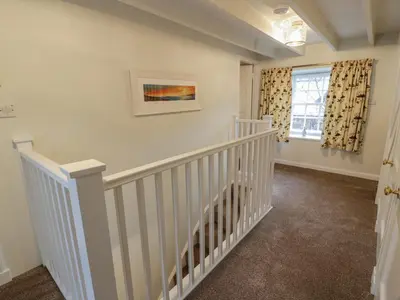 a white staircase in a home with a window at Blue Door - Kirkcudbright in Kirkcudbright