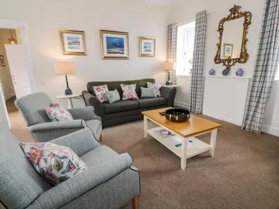 a living room with two couches and a coffee table at Royal Artillery Cottage - Culzean Castle in Maybole