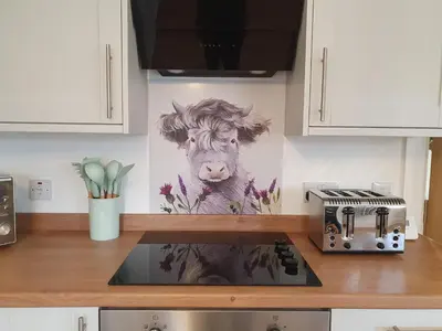 a painting of a cow on the wall of a kitchen at 2-Bed Barn Hot Tub & Pet Friendly near Muirkirk in Cumnock