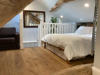 a bedroom with a bed and a mirror and a chair at The Annex in Carlisle