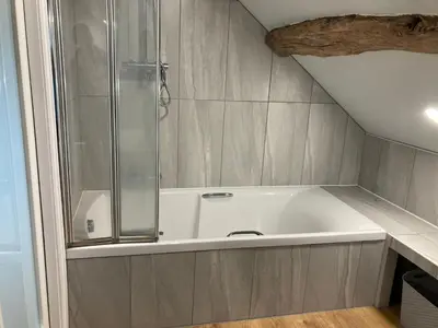 a bathroom with a bath tub with a shower at The Annex in Carlisle