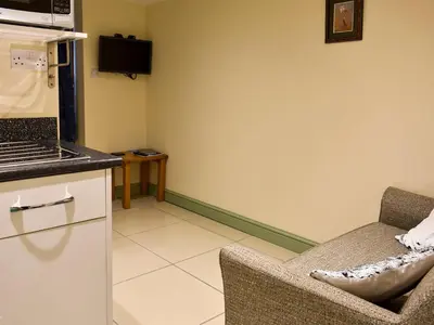 a living room with a couch and a kitchen at Danika East in Threlkeld
