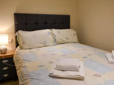 a bedroom with a bed with two towels on it at Danika East in Threlkeld