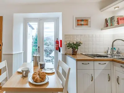 a kitchen with a table with a plate of bread on it at The Plosh in Keswick