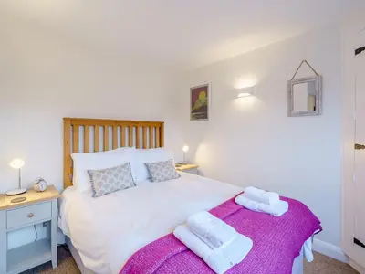 a bedroom with a large white bed with towels on it at The Plosh in Keswick