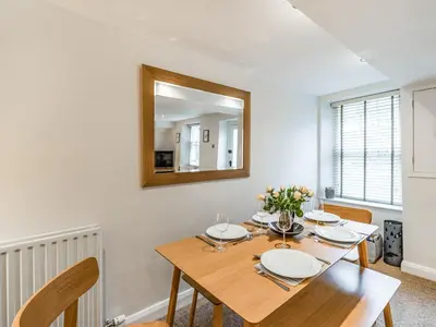 a dining room with a table and a mirror at The Plosh in Keswick