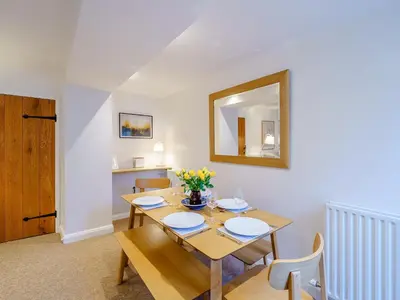 a dining room with a table and a mirror at The Plosh in Keswick
