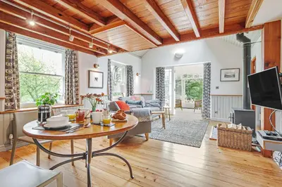 a living room with a table and a couch at The Stable At Oakbank in Elterwater