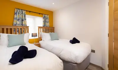 two beds in a room with yellow walls at Fell View in Keswick