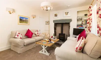 a living room with two couches and a table at Oxen Fell Cottage in Little Langdale