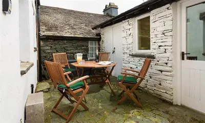 a patio with a table and four chairs at Oxen Fell Cottage in Little Langdale