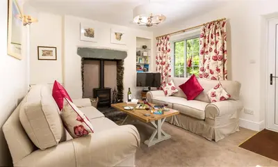 a living room with two couches and a table at Oxen Fell Cottage in Little Langdale