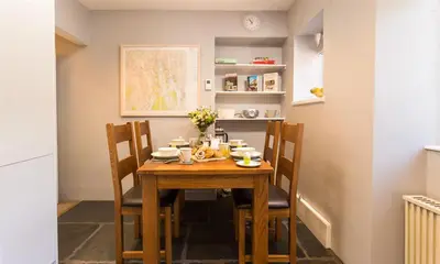 a dining room table and chairs in a room at Oxen Fell Cottage in Little Langdale
