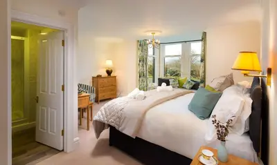 a bedroom with a large bed and a window at One The Howe in Portinscale