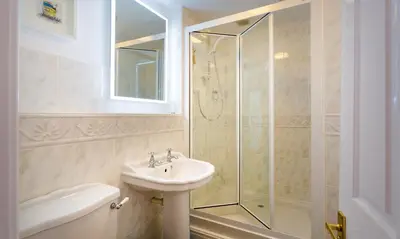 a bathroom with a sink and a glass shower at One The Howe in Portinscale