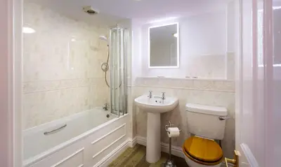 a bathroom with a toilet and a sink and a tub at One The Howe in Portinscale