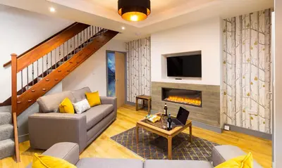 a living room with a couch and a fireplace at Sunnybank Cottage in Keswick