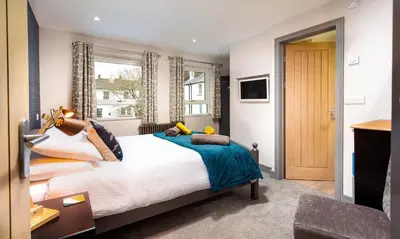 a bedroom with a large bed and a window at Sunnybank Cottage in Keswick
