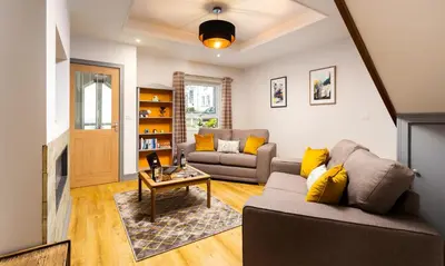 a living room with a couch and a table at Sunnybank Cottage in Keswick