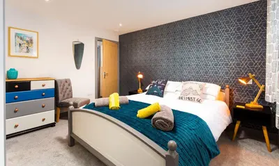 a bedroom with a bed with a blue accent wall at Sunnybank Cottage in Keswick