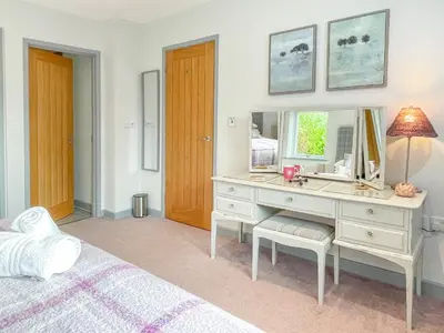a bedroom with a desk with a mirror and a bed at Merlestead in Applethwaite