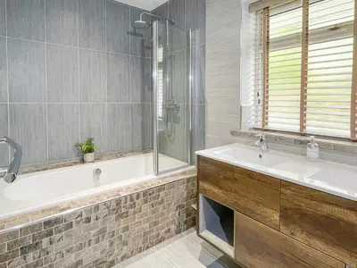 a bathroom with a tub and a sink and a shower at Merlestead in Applethwaite