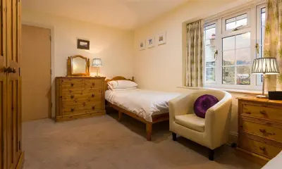 a bedroom with a bed and a chair and a window at Grange Fell Borrowdale in Keswick