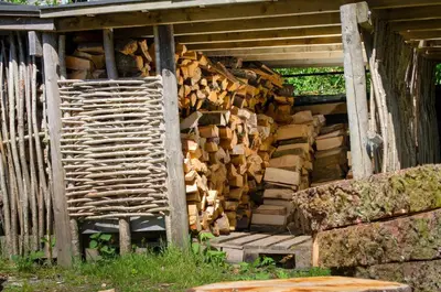 a pile of fire wood in the side of a building at Oakbank in Elterwater