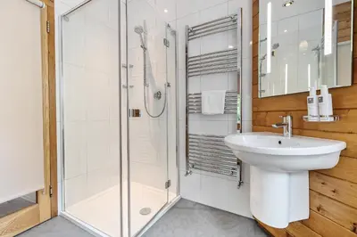 a white bathroom with a sink and a shower at Oakbank in Elterwater
