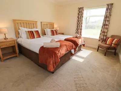 a bedroom with two beds and a window at Laal Field House in Keswick