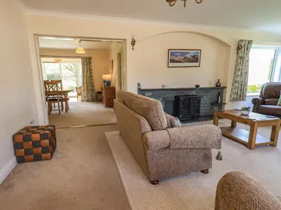 a living room with a couch and a chair and a fireplace at Laal Field House in Keswick