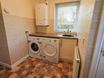 a kitchen with a washing machine and a sink at Laal Field House in Keswick