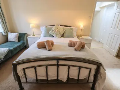 a large bed in a living room with two lamps at Laal Field House in Keswick
