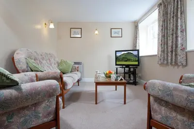 a living room with a couch and a tv at Low Croft Cottage in Grasmere