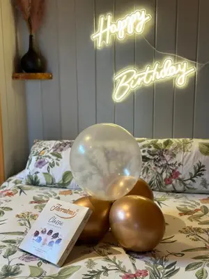 a balloon on a pile of balls on a bed at The Stag Pod Farm Stay with Hot Tub Sleeps 2 in Galston